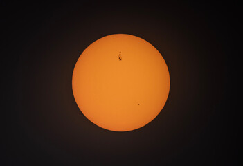 The orange coloured afternoon sun glowing with many large sunspots against a black background on May 2, 2025 Ottawa, Canada