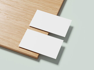 A white business card placed diagonally on a wooden background, casting a soft shadow and highlighting its clean lines.