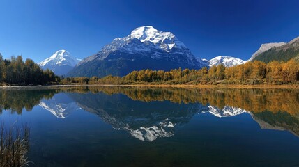 Obraz premium Majestic mountains reflected in a serene autumn lake.