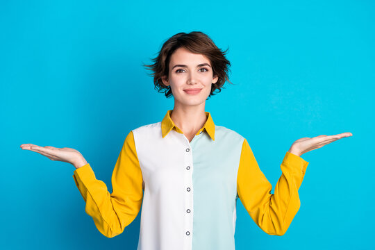 Photo of positive good mood lady dressed shirt compering two arms empty space isolated blue color background