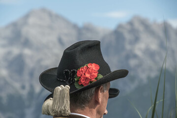 Mann mit Tiroler Trachtenhut vor Bergkulisse