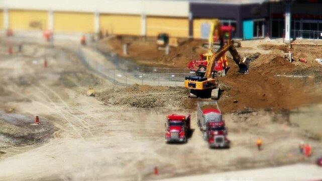 Bulldozers, excavators, dump trucks and other heavy machinery equipment on a construction job work site moving dirt in Ontario, Canada. All logos and symbols removed. Shot in tilt shift timelapse.