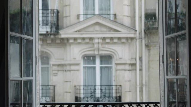 Rain falling outside apartment window in paris