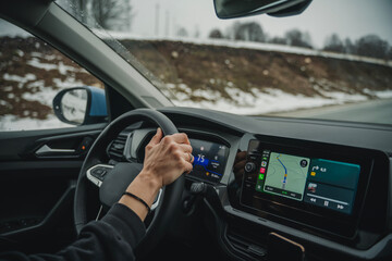 Auto travel concept, woman driving car in winter wilderness with map navigator