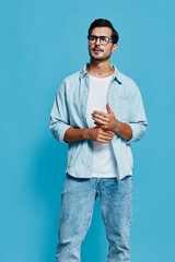 Full body smiling man wearing light denim shirt and eyeglasses, looking at the camera with a...