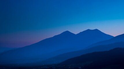 Mountain silhouette under twilight sky, serene blue tones blending into dusk, nature's quiet grandeur
