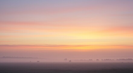 Fototapeta premium Serene Pastel Sunrise over Misty Field with Distant Figures