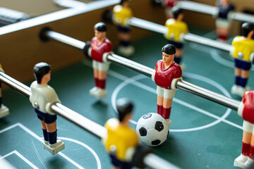 Detailed image of a foosball game in progress, focusing on the players and ball.