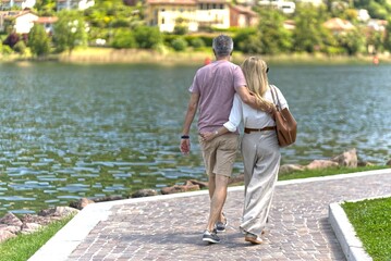 Older couple walking arm in arm.