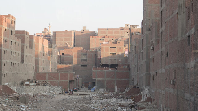 Stock photo of a dense urban landscape in a developing country, showing brick buildings and rubble in the foreground.