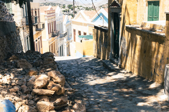 Fototapeta Picturesque alleyway in a Greek village, featuring traditional architecture and cobblestone streets.