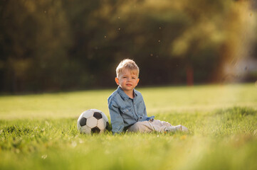 Naklejka premium Little boy is having fun on the field outdoors