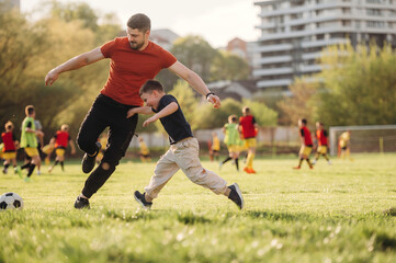 Obraz premium Game of soccer. Father and son are having fun outdoors