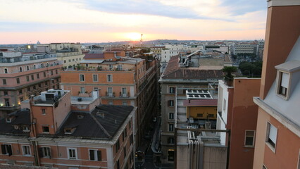 Naklejka premium Stunning sunset view over the rooftops of Rome, Italy. Historic buildings and cityscape at golden hour.