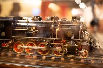 Detailed close-up of an antique model steam locomotive, showcasing intricate details and craftsmanship.