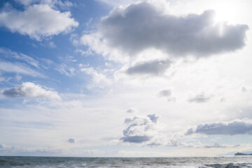 Sea waves and bright blue sky with scattered white clouds on sunny day. Sea after storm. Peaceful seascape with horizon line, nature, summer, vacation, travel background