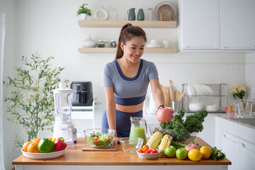 Young woman making make a nutritious vegetable smoothie with leafy greens and colorful fruits at home.