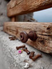 Rusty metal bolts and screws on weathered wooden planks near sandy beach or shoreline