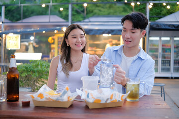 Casual travel dining moment with couple sharing food and preparing drinks together.