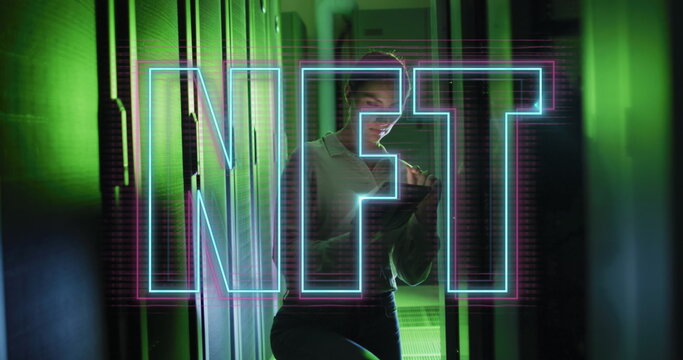 Image of nft text over caucasian woman using tablet in server room - Powered by Adobe