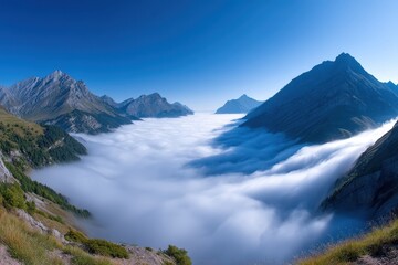 Obraz premium A stunning mountain valley filled with clouds under a clear blue sky.