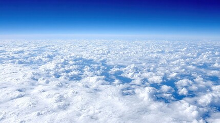 Naklejka premium A vast expanse of fluffy white clouds seen from above with a deep blue sky stretching into the horizon.