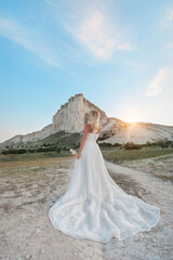 a woman in a white dress, a bride on a mountain with a blue sky. Beautiful nature, freedom, enjoyment of life. High quality photo