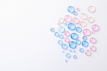 Water droplets in various sizes and colors arranged artistically on white background