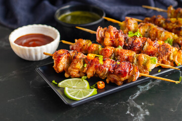 Chicken satay is grilled, marinated chicken skewers served with a rich, savory peanut sauce,...