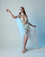 Fantasy studio portrait of a red-haired mermaid faery wearing a white pearl gown, fairytale...