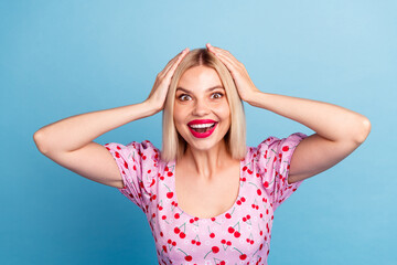 Photo of overjoyed adorable girl wear stylish pink print clothes isolated on blue color background