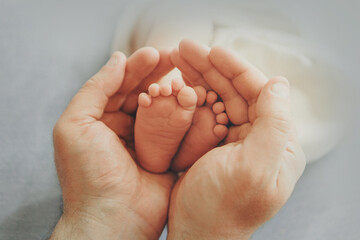 A newborn baby in diapers. A baby in the hands of a mother, maternal love, family, childbirth, having many children. Children's clothes, booties. High quality photo