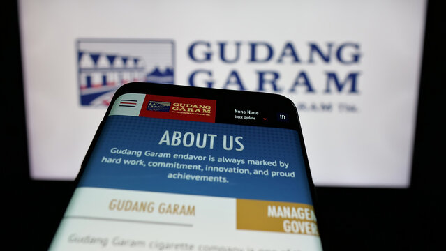 Stuttgart, Germany - 05-02-2025: Mobile phone with webpage of Indonesian tobacco company Gudang Garam on screen in front of logo. Focus on top-left of phone display.