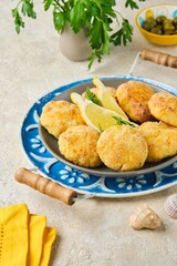 Fish cutlets from white sea fish in golden breading in a ceramic plate on a light concrete background. Recipes fish, seafood.
