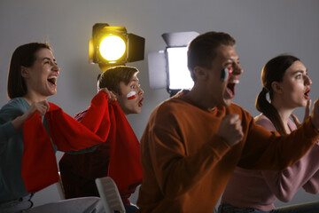Emotional sports fans watching game together indoors