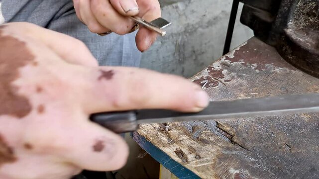 Top close-up shot of an Indian locksmith manually making a duplicate house key.manual key making
