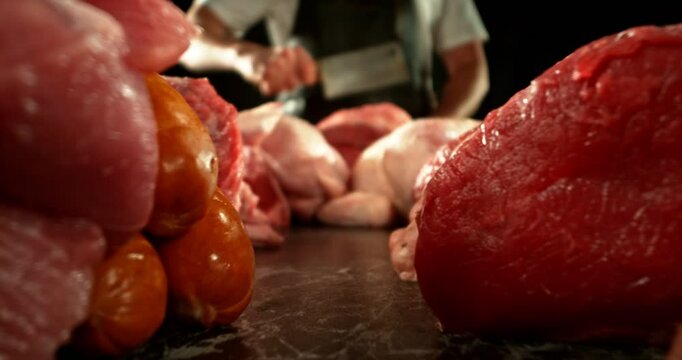Super Slow Motion of Butcher Hitting the Raw Meat by Cleaver. Filmed on High Speed Cinema Camera.  Meat Preparation Concept, Fire on Background. Camera Placed on Motion Control System.