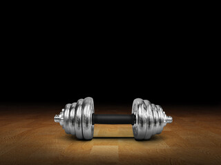 Silver dumbbells placed on a wooden floor, black background.