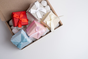 Beautiful gift boxes with ribbons in a big box on a white background. Delivery. Festive events sales concept
