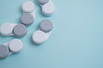 Contact lenses, case and bottle with solution and eye drops on white background. Eye health and care, vision, ophthalmology concept, close-up 