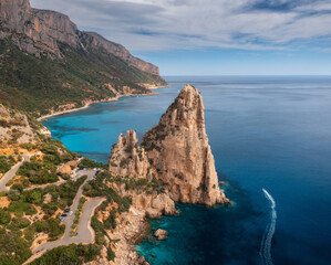 Aerial view of rock and mountains, blue sea bay, beach, boat on sunny summer day. Sardinia Island,...