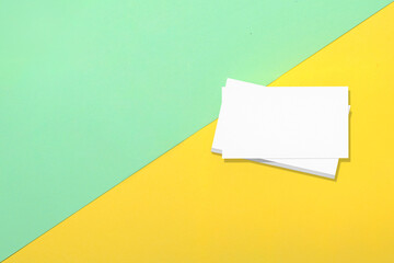 Top view of business business cards on colored background. Blank paper or sheet. Mockup or copy space for your design