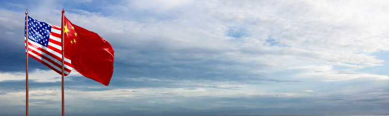 Flags of the USA or the United States of America and China waving with a blue sky background....