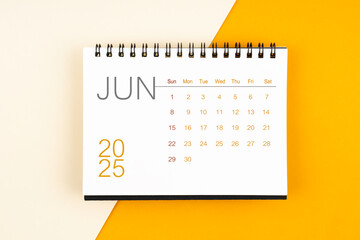 Desk calendar for June 2025 year on yellow background, Flat lay.
