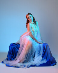 Fantasy studio portrait of a red-haired mermaid faery model wearing a white pearl gown, fairytale...
