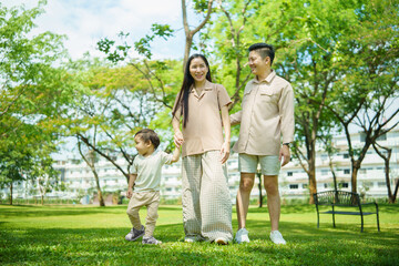 Carefree family enjoying a walk together in a green park on a sunny day.