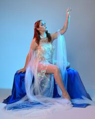 Fantasy studio portrait of a red-haired mermaid faery model wearing a white pearl gown, fairytale...