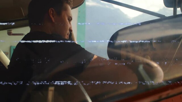 male pilot using headset and gripping yoke in aviation cockpit with mountain, with glitch overlays