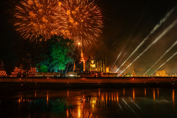 Fototapeta premium Spectacular light and sound show at Sukhothai Historical Park, a UNESCO World Heritage Site, celebrating ancient Thai culture with fireworks, illuminated temples