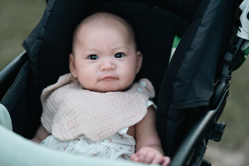 Adorable baby sits comfortably in a stroller, exploring the outdoor world with curiosity, calmness, innocence, charm, gentleness, wonder, safety, freshness, warmth, and delightful early experiences